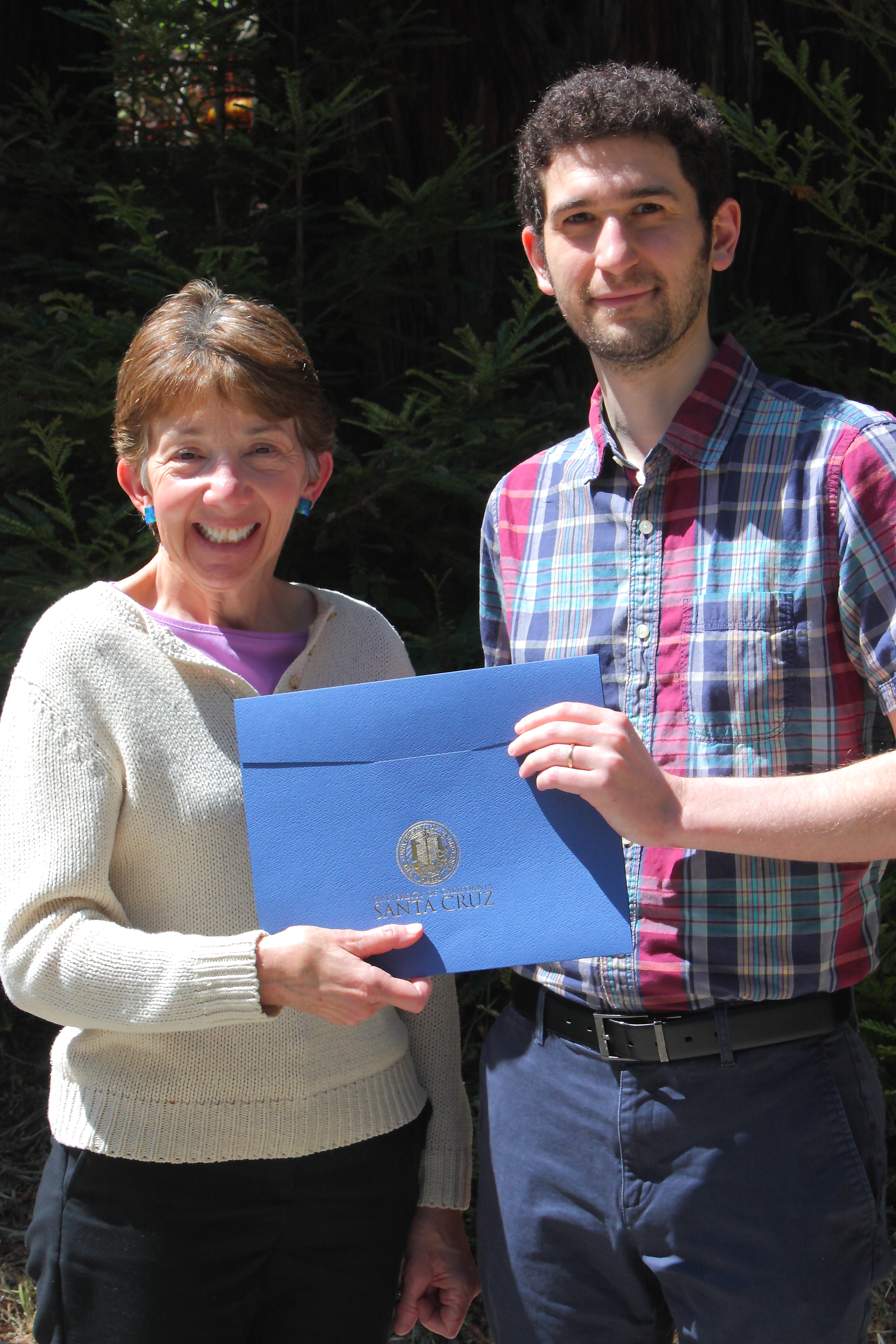 lori-kletzer-gives-benjamin-lehmann-his-steck-family-prize-for-graduate-research-excellence-certificate-outside-kerr-hall-on-may-1,-2019.jpg